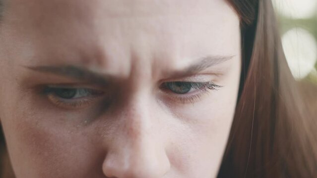 Close up of depressed frustrated young Caucasian woman feeling stressed, sick, tired lady alone at home, thinking over bad news, problems, crisis concept. Face of serious sad female with sad eyes