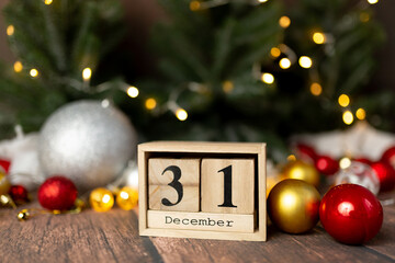 Old vintage wooden calendar set on the 31 of December with pine cone