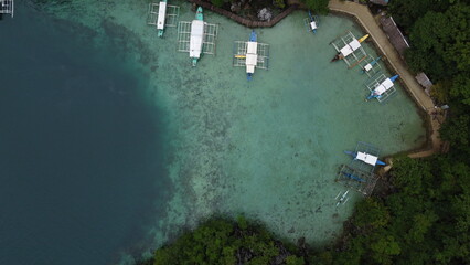 Coron's Blue Lagoon, dotted with boats, offers a tranquil vacation scene amidst crystal waters.