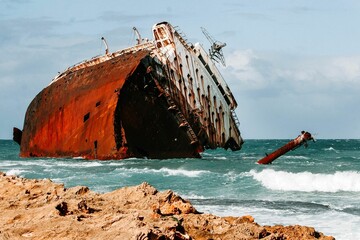 Large shipwreck stranded on the coast in  crystal-clear water