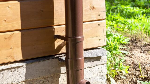 New plastic rainwater drain pipe on a wooden house