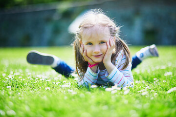 Happy cheerful preschool girl walking in park