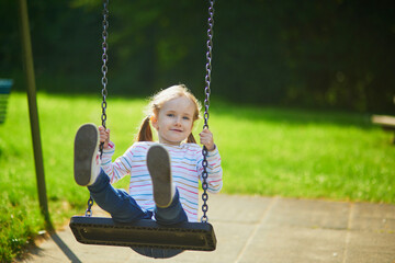 Happy 5 years old girl on a swing