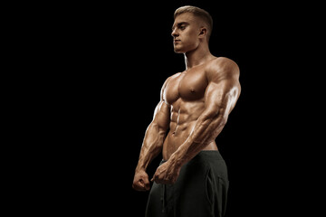 Young bodybuilder abs core muscle posing isolated on black background