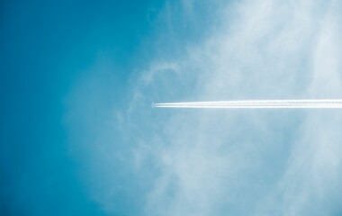 a plane flying through the sky on a sunny day in the clouds