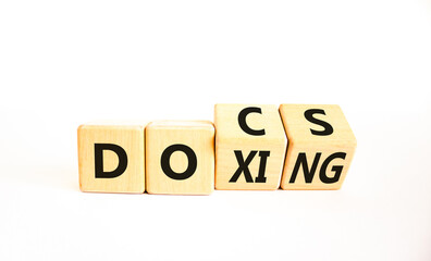 Docs or doxing symbol. Concept words Docs Doxing on wooden block. Beautiful white table white...