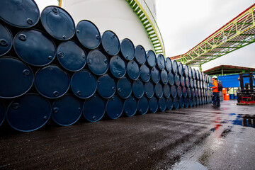 Male worker inspection record drum oil stock barrels blue vertical