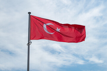 The national flag of Turkiye waving in the blue sky