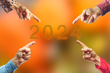 2024, People pointing to the number 2024 on orange background. Happy New Year