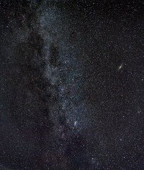 Starfield within Milky Way galaxy, with the Andromeda galaxy showing in the distance