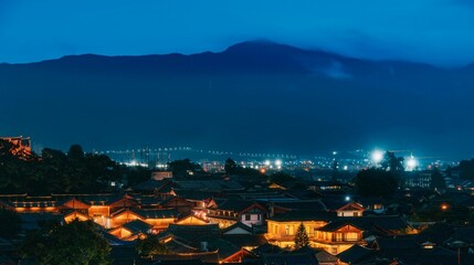 the lights on a town in the distance and mountains in the distance