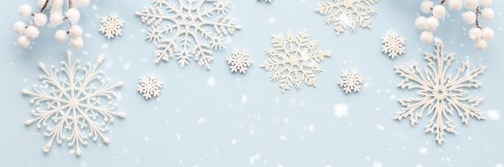 White snowflakes and rowan branches on a blue background, Christmas background, Merry Christmas and Happy New Year banner, top view, copy space