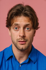 Obraz premium Young man looking at camera isolated over pink wall