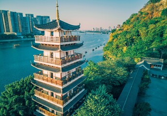 Setting sun shines on a tower by the river in Liuzhou, Guangxi, China, Asia