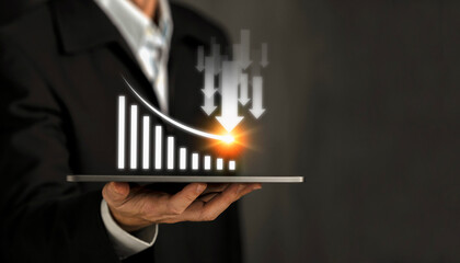 Businessman handle tablet show a trend down virtual graph finance,  invest in trading. Planning analyze indicator and strategy buy and sell, Stock market concept.  