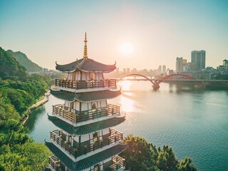 Setting sun shines on a tower by the river in Liuzhou, Guangxi, China, Asia