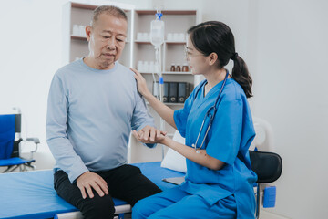Obraz premium Beautiful Asian female nurse in a nursing uniform talks to a senior patient at the bedside in a hospital or clinic department.