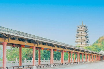 Fototapeta na wymiar A tower and a corridor with red columns under the blue sky in Liuzhou, Guangxi, China, Asia