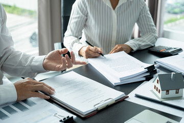 Businesswoman embraces client after successful property negotiation.