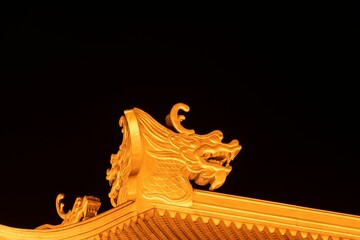 Night view of a Chinese dragon head ridge decoration on temple roof in Liuzhou, Guangxi, China, Asia