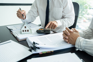 Businesswoman embraces client after successful property negotiation.