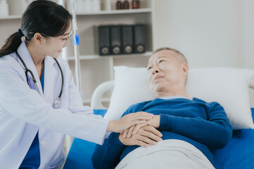 Fototapeta premium Beautiful Asian female doctor in white top talking with senior patient at bedside in hospital or clinic ward