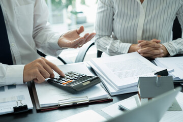 Businesswoman embraces client after successful property negotiation.