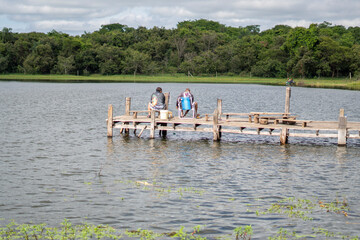 Fototapeta na wymiar Fishermen on a pier on the Borá River, a tributary of the Tietê, an important Brazilian river
