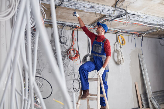 Electrician working on a wire system on a construction site.
