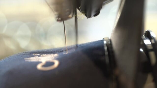 Automatic sewing machine needle in work process. Close-up of sewing machine needle in motion rapidly moves up and down.