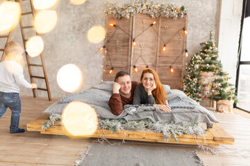 portrait of a couple on the bed near the New Year tree. the winter vacation. Christmas morning...