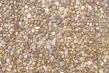 Texture of the surface of a wall made of concrete and small stones.