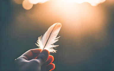 Feather in hand with sunlight background, soft focus and vintage tone