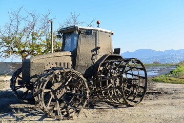 Fototapeta na wymiar Aged tractor sits abandoned under a blue sky