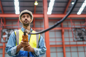 Factory worker - technician controlling a heavy crane in factory close up at his hands holing a...