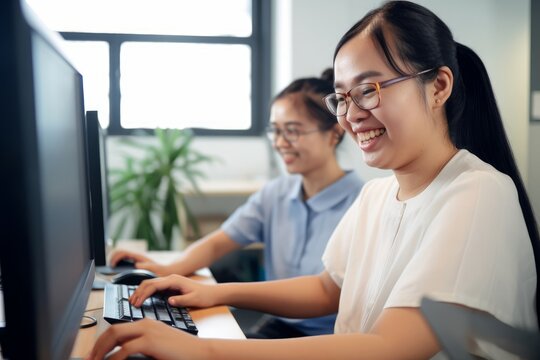 Happy Asian women co-workers in office workplace including person with blindness disability using computer with refreshable braille display assistive device. Disability inclusion at work,Generative AI