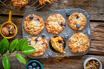 Carrot muffin with blueberries and walnuts.  Wooden background. Top view. 