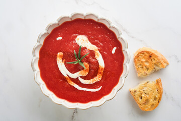Soup. Tomato cream soup or gazpacho with herbs, seasonings, cherry tomato and parsley in white bowl on light grey stone background. Healthy vegetable soup. Spanish cold soup. Top view with copy space