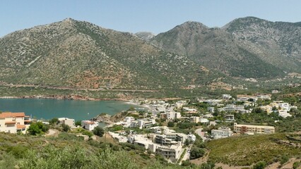 Fototapeta na wymiar Aerial view of the town of Elounda in Crete, Greece with a stunning landscape of rolling hills