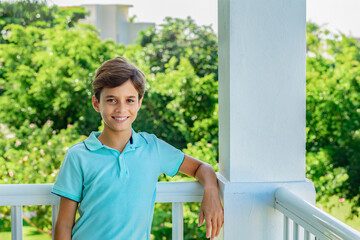 Handsome smiling teenager, portrait on green garden background