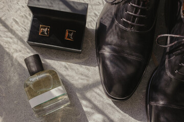 details of grooms getting ready: leather shoes, parfum and cufflinks