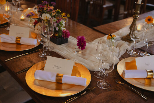 cozy elegant golden table setting of a wedding with coloful flowers and candles
