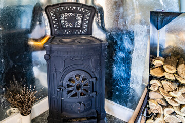 Cast iron fireplace, stacked firewood.