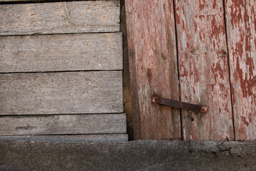 part of an old wooden shed and a door with a metal handle, a slate element from below