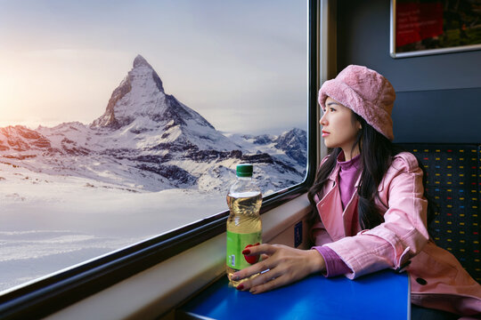 Tourist looking out the window enjoying with the Matterhorn mountain while sitting in the train, Zermatt in Switzerland.