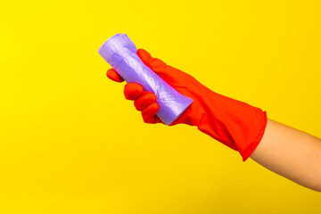 Woman's hands holding a garbage bag on a colored background. roll with plastic bags for garbage on...
