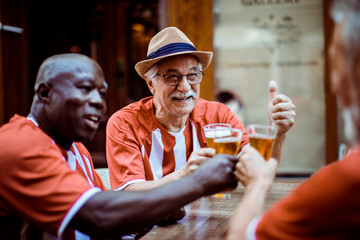 Senior sports fans having beer in the city