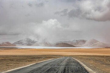 Ali region of Tibet with a winding road, vast mountains, and sprawling fields - obrazy, fototapety, plakaty