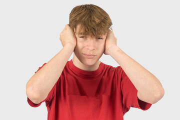 Fototapeta premium Headshot of a teenage boy covering his ears