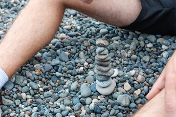 Athletic man collecting stones on the seashore
